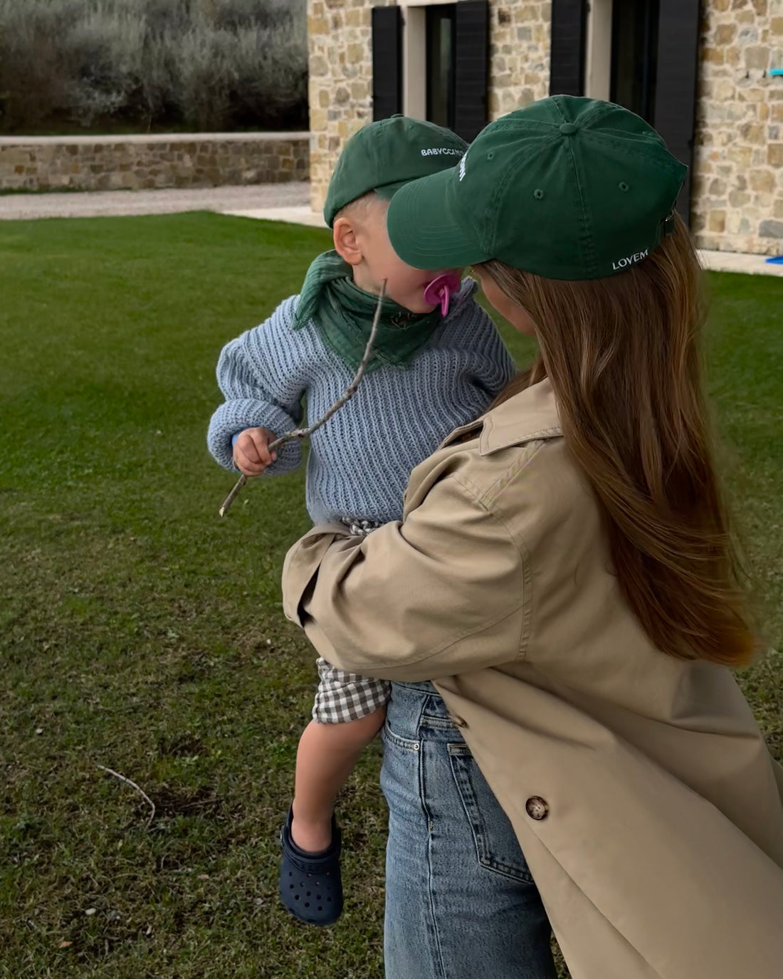 Frau mit LOVEM Cap Negroni hält Junge auf dem Arm mit gleichem Cap von LOVEM für Kinder.