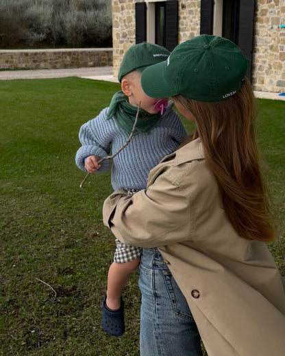 Frau mit LOVEM Cap Negroni hält Junge auf dem Arm mit gleichem Cap von LOVEM für Kinder.